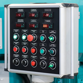 Industrial control console with switches, push buttons and digital controllers. Selective focus.