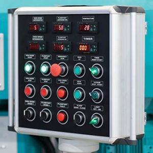 Industrial control console with switches, push buttons and digital controllers. Selective focus.